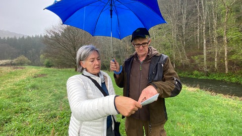 Birresborns Bürgermeisterin Christiane Stahl (links) schaut sich mit Heinz Thewes auf einer Karte das Gebiet an, das von der Sperrung des Bahnübergangs betroffen ist. Insgesamt mehr als sieben Hektar.