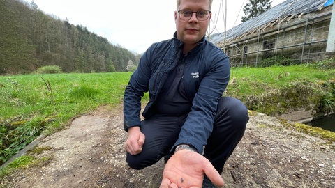 Simon Schloß ärgert sich über das blaue Granulat, dass sich immer noch überall entlang der Kyll findet. 