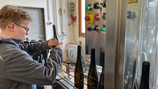 Alice vom Solzialwerk des DRK in Bernkastel-Kues füllt Weinflaschen ab, die in ganz Deutschland verkauft werden. 