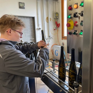Alice vom Solzialwerk des DRK in Bernkastel-Kues füllt Weinflaschen ab, die in ganz Deutschland verkauft werden. 