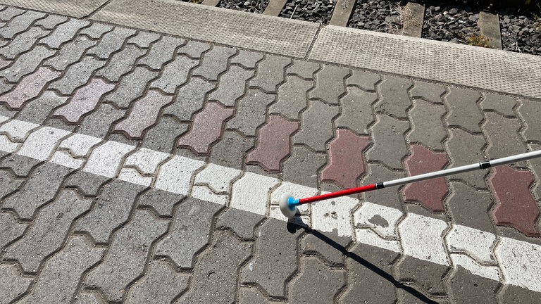 Ein weißer Streifen auf dem Plaster am Bahngleis im Bahnhof Trier - blinden Menschen hilft das nicht, denn er ist nicht ertastbar. 