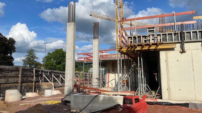 Im vorderen Teil der Baustelle vorne an der Südalles ziehen sich die Betonwände nach oben. Der Baukran steht im Hintergrund.