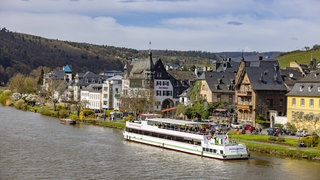 Ein Ausflugsschiff liegt am Moselufer in Traben-Trarbach