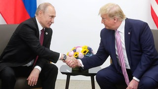 Trump und Putin (l.) geben sich die Hand bei einem früheren Gipfel. Nun treffen sie sich in Alaska und verhandeln über den Ukraine-Krieg. Ukrainer in Trier sind skeptisch.