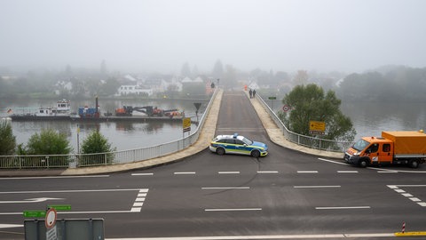 Ein Polizeifahrzeug versperrt die Fahrbahn der Moselbrücke bei Longuich. Dort hat ein Frachtschiff nachts die Brücke beschädigt. Das Schiff hat bei der Bergabfahrt vorher in Schweich eine weitere Brücke gerammt.