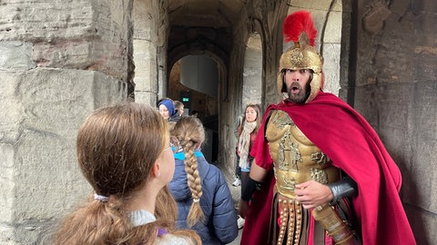 Schauspieler Sebastian Gasper als römischer Centurio mit Kindern in der Porta Nigra. 