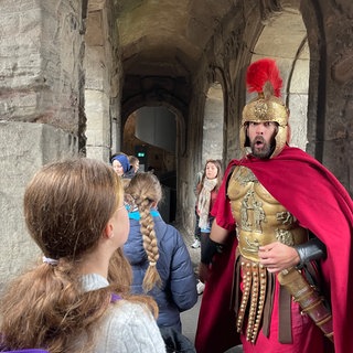 Schauspieler Sebastian Gasper als römischer Centurio mit Kindern in der Porta Nigra. 