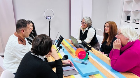 Geflüchtete in Daun diskutieren darüber, welches Thema demnächst im Podcast behandelt werden sollte.
