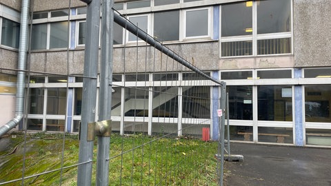 Vor dem L-Gebäude der IGS in Trier steht ein Bauzaun. 