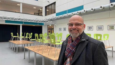 Schulleiter Dirk Schönhofen steht in der Aula des C-Gebäudes. 