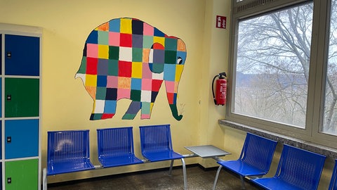 Ein bunt-karierter Elefant wurde auf eine Wand im Treppenhaus gemalt.  