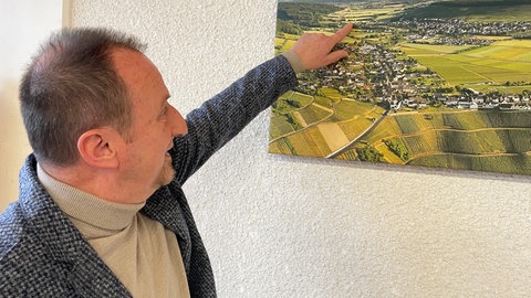 Ortsbürgermeister Armin Kohnz zeigt auf der Karte, wo das neue Gewerbegebiet entstehen soll. 