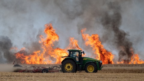 Ein Traktor auf dem Feld beim Löschen eines Brandes