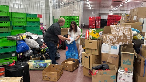 Anna Stetska und Tobias Schneider räumen Ukraine-Spenden in Säcke und Kisten.