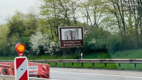 Derzeit verdeckt von einer Baustelle, weist dieses Schild an der A1 auf die Stadt Trier mit ihrem Weltkulturerbe hin.