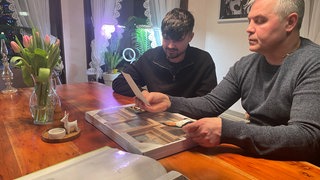 Michael und Daniel Ovsjannikov blättern in einem Album mit Fotos von Micha, der auf der Säubrennerkirmes erstochen wurde.