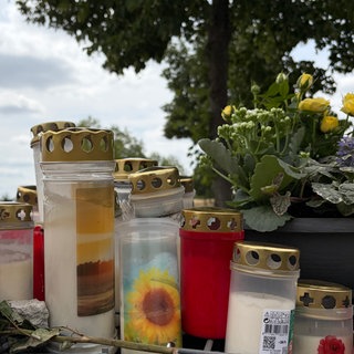 Ein Student ist in Trier auf offener Straße erstochen worden. Am Tatort haben Menschen Kerzen und Blumen niedergelegt.
