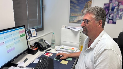 Der Arzt Dirk Röhlich arbeitet am PC in seiner Arztpraxis in Trier, die auch eine Long Covid Ambulanz ist.