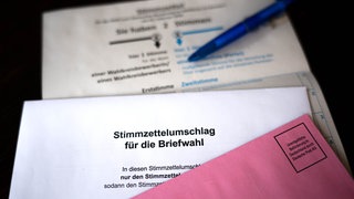Weißer Stimmzettelumschlag für die Briefwahl zur Bundestagswahl 2025 und roter Wahlbriefumschlag