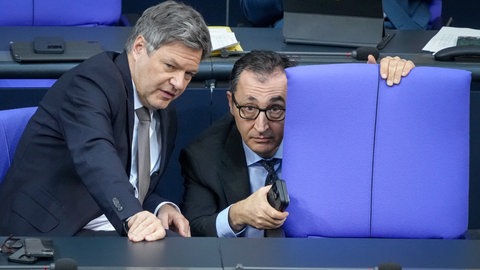 Robert Habeck (Bündnis 90Die Grünen, l), Bundesminister für Wirtschaft und Klimaschutz, und Cem Özdemir (Bündnis 90Die Grünen), Bundesminister für Ernährung und Landwirtschaft und Bundesminister für Bildung und Forschung, nehmen im Plenum des Bundestags im Reichstagsgebäude an der Sitzung teil.