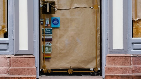 Der Eingang und die Schaufensterfront eines Geschäfts in der Hauptstraße, einer Fußgängerzone und Einkaufsstraße in der Heidelberger Innenstadt, ist mit Papier beklebt. 