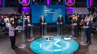 Kurz vor Beginn der Wahlarena (von l. n. r.): Moderator Florian Weber, Mersedeh Ghazaei (Linke), Andreas Stoch (SPD), Cem Özdemir (Grüne), Hans-Ulrich Rülke (FDP), Manuel Hagel (CDU) und Markus Frohnmaier (AfD) 