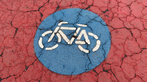 Rot markierter Radweg mit blauem Radfahr-Symbol in Mannheim-Neckarau