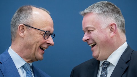 Der RLP-Wahlsieger Gordon Schnieder lachend im Gespräch mit Bundeskanzler Friedrich Merz, beide von der CDU.