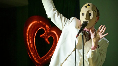 Schauspieler Carl Grübel bei Liederabend mit weißer Maske