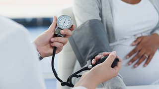 Schwangere beim Arzttermin zur Blutdruckmessung