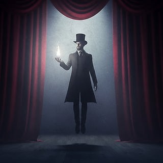 Ein Medium mit Zylinder schwebt auf einer dunklen Bühne zwischen roten Vorhängen. In seiner ausgestreckten Hand hält er eine hell leuchtende Flamme.