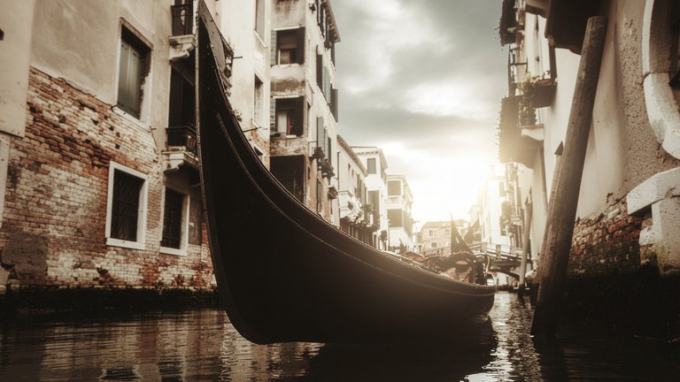 Eine Gondel liegt in einem engen Kanal in Venedig