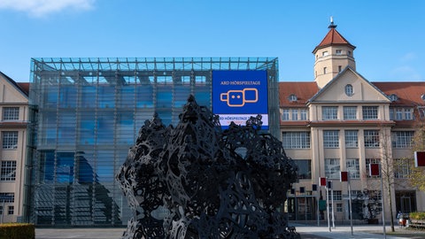 Das Zentrum für Kunst und Medien mit der Installation "The Morning Line" und dem Hörspieltage-Plakat auf dem Kubus