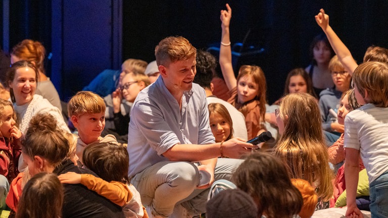 Moderator mit den Kinder beim Interaktiven Hörspiel Abenteuer in der Unterwelt
