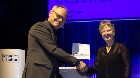 Kai Gniffke, Intendant des SWR, überreicht die Urkunde an die Karl-Sczuka-Förderpreisträgerin 2023 Leona Jones