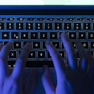 Finger an einer Laptop-Tastatur