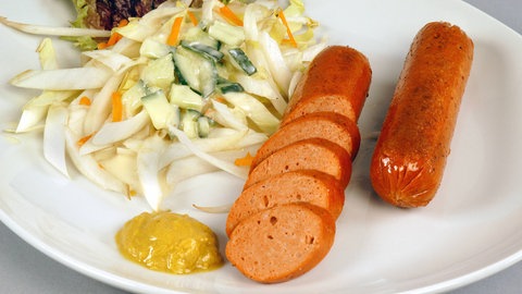 Vegetarische Wurst auf Teller mit Senf und Salat