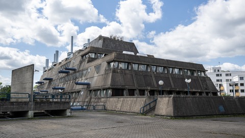 Das ehemalige brutalistische Institut für Hygiene und Mikrobiologie gehört zu Berliner Charité und ist wegen seiner früheren Tierlaboratorien auch als „Mäusebunkerhe“ bekannt. Wegen der auffälligen Architektur wurde diskutiert, das Gebäude komplett abzureissen. Jedoch setzten sich viele Menschen dafür ein, es zu retten. Seit 2023 steht der Mäuserbunker unter Denkmalschutz.