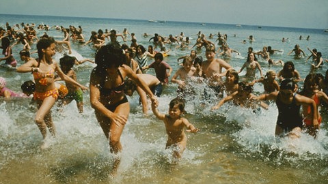 Panik am Strand, Menschen rennen aus dem Wasser