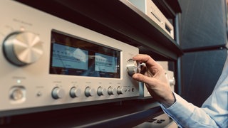 Eine Hand dreht an einem Radioregler