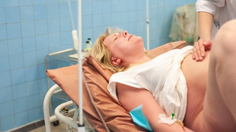  In the maternity hospital, a woman pushes before giving birth.