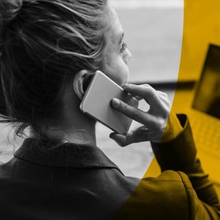 Eine Geschäftsfrau telefoniert mit Handy in einem Café