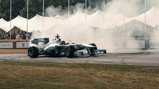 Rennwagen (Bolide) auf der Rennbahn mit qualmenden Reifen