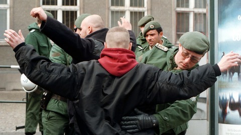 Polizeibeamte durchsuchen am 14.3.1998 am Bahnhof von Saalfeld einige Teilnehmer einer NPD-Demonstration. 