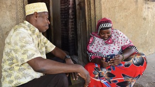 Insel Pemba, Tansania: Eine Dorfbewohnerin schaut das Video einer OP, bei der Würmer aus dem Darm entfernt werden.