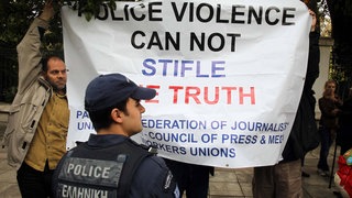 Local photo-reporters hold a banner outside the Presidential Mansion in Athens, Greece, April 11, 2012. Greek press unions staged new protests on Wednesday over the injury of a Greek photojournalist by police during an anti-austerity protest in Athens last week, calling for justice.