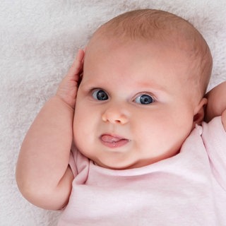 Baby zeigt Zunge: Vom ersten Brabbeln bis zum grammatikalisch korrekten Satz machen Kinder eine komplexe Entwicklung durch