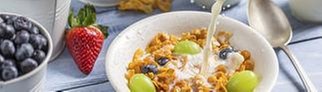 Müsli in einer Schale daneben frisches Obst