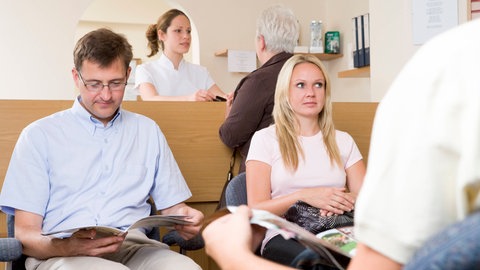 Ein Mann und eine Frau im Wartezimmer: Die Gendermedizin rückt das Geschlecht in den Fokus, fordert Medikamentenstudien auch an Probandinnen und sorgt so für bessere Therapien für Frauen 