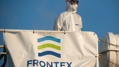 Ein Mitglied der Europäischen Grenz- und Küstenwache Frontex in einen Schutzanzug auf einem Patrouillenschiff im Hafen von Malaga